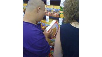 A participant looks at a food label during a field trip to a local grocery store