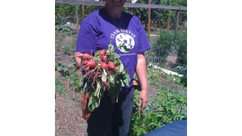 Mary, the garden coordinator, shows off radishes that participants harvested