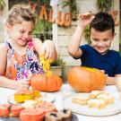 children carving pumpkins