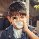 a boy drinking a glass of milk