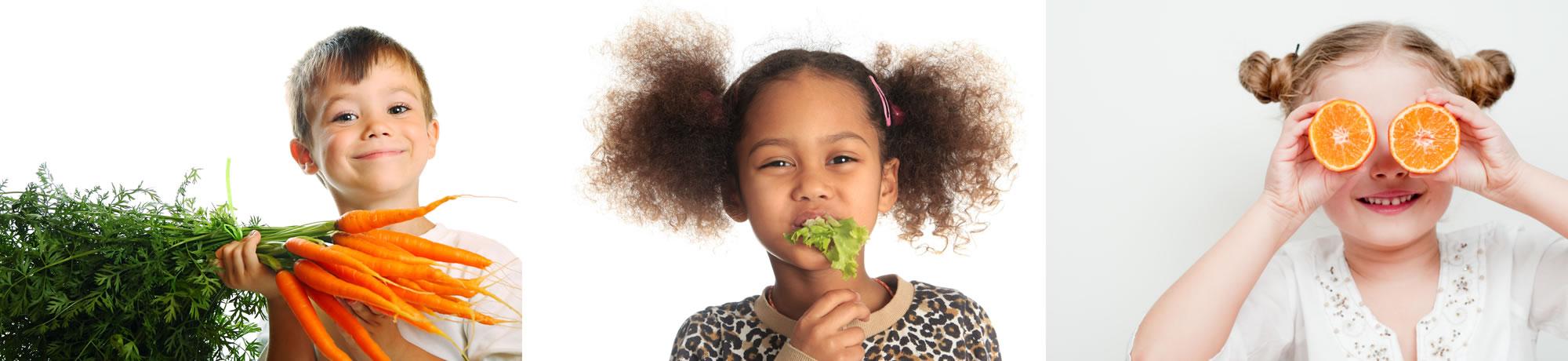 Kids holding up a fruit or vegetable.